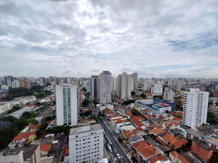 Panorama urbano da Vila Clementino em dia nublado, mostrando o trânsito em avenidas e a densidade de prédios residenciais e comerciais do bairro.