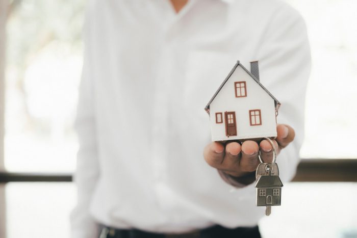 pessoa segurando casa em miniatura, representando o que é ITBI