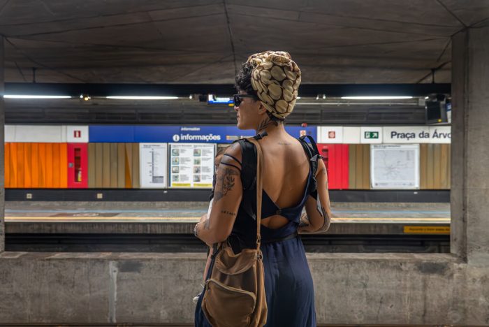 Mulher carregando um bebê no colo enquanto aguarda na plataforma da estação Praça da Árvore, na Linha 1-Azul do metrô de São Paulo.