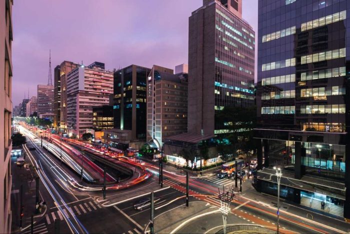 Prédios comerciais e vias iluminadas na capital paulista, representando opções de mobilidade, lazer e gastronomia para quem busca o que fazer em São Paulo à noite.