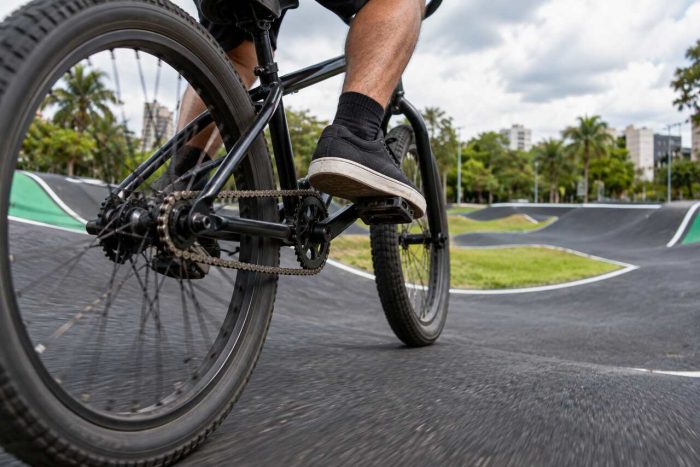 Ciclista pedala em pista de parque, com roda e pé em destaque, ilustrando o que fazer em Moema entre opções de lazer ao ar livre.